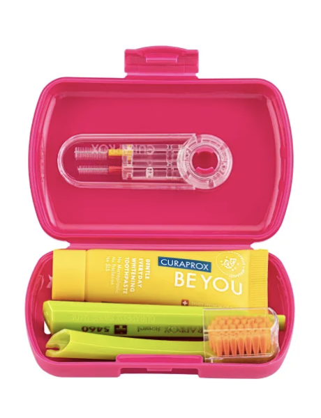 Open Curaprox pink travel set showing brush, toothpaste and interdental brushes