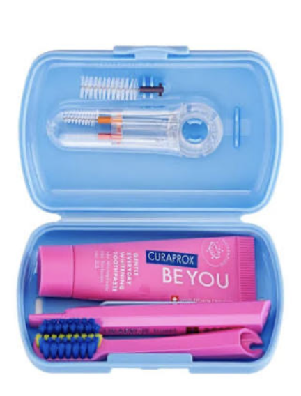 Open Curaprox blue travel set showing brush, toothpaste and interdental brushes